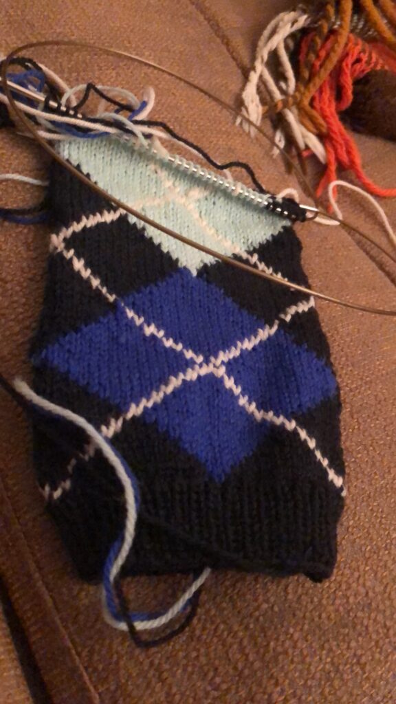 An argyle sock in the process of being knit. 